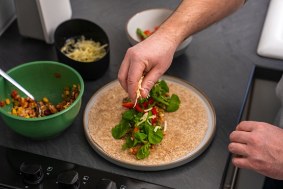 someone making a salad wrap