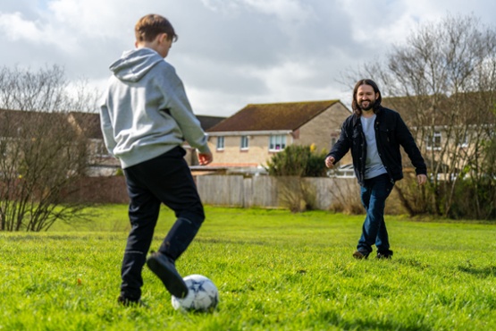 A man and a boy playing football